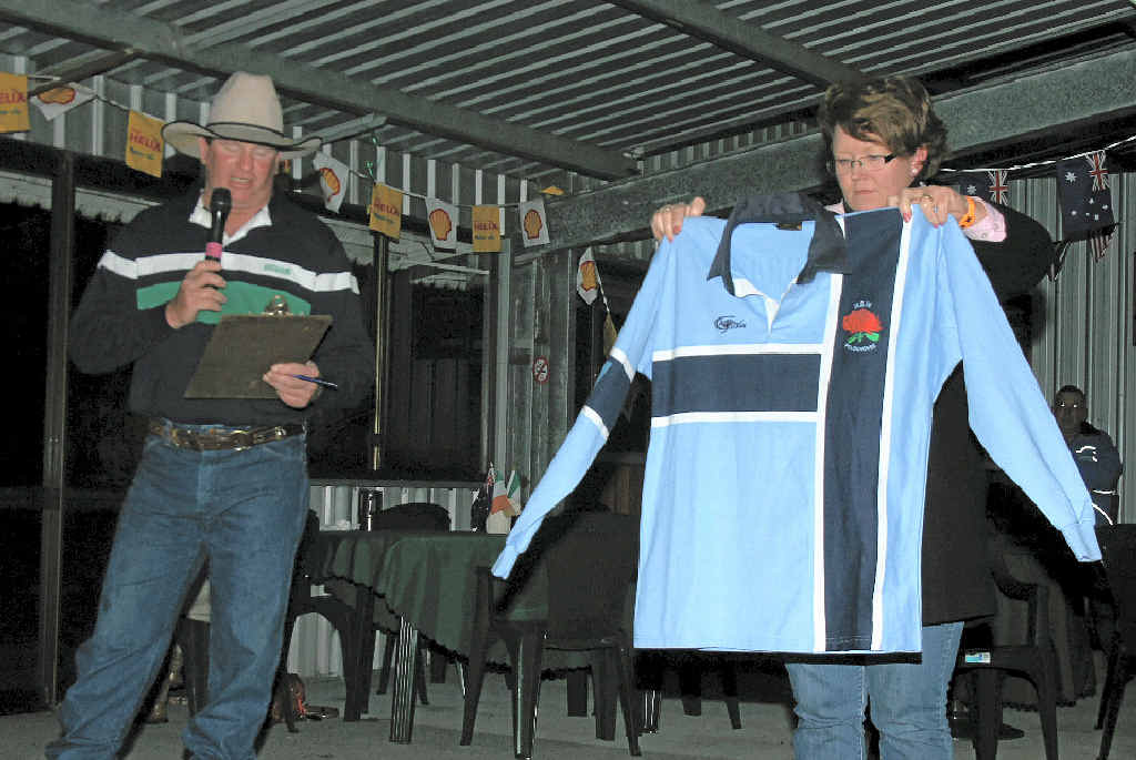 Auctioneer Justin Hafey and auction organiser Naomi Strong with the NSW jersey which went up for auction.